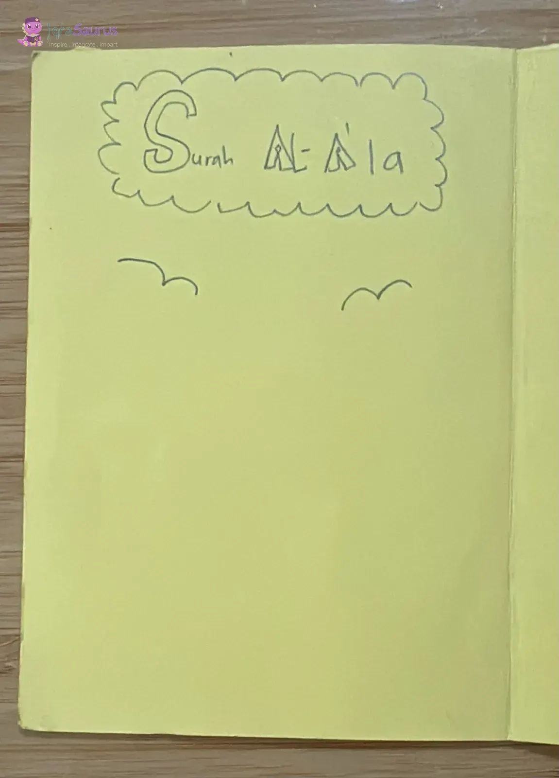A yellow page with Surah Al-A'la written inside a cloud shape and two birds flying below.