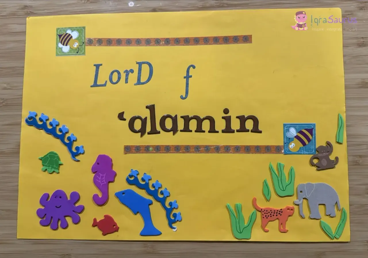 A yellow card with sticker letters and foam sea creatures and land animals, made for the second verse of Al-Fatihah